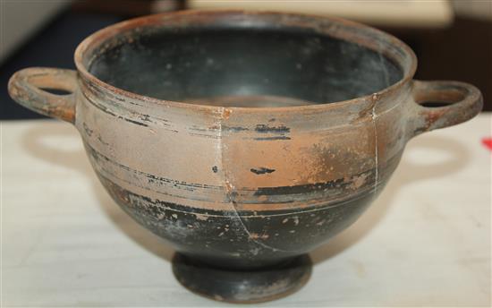 A Greek black slip decorated skyphos, Apulia, c.4th century BC, 22.5cm, broken and re-assembled